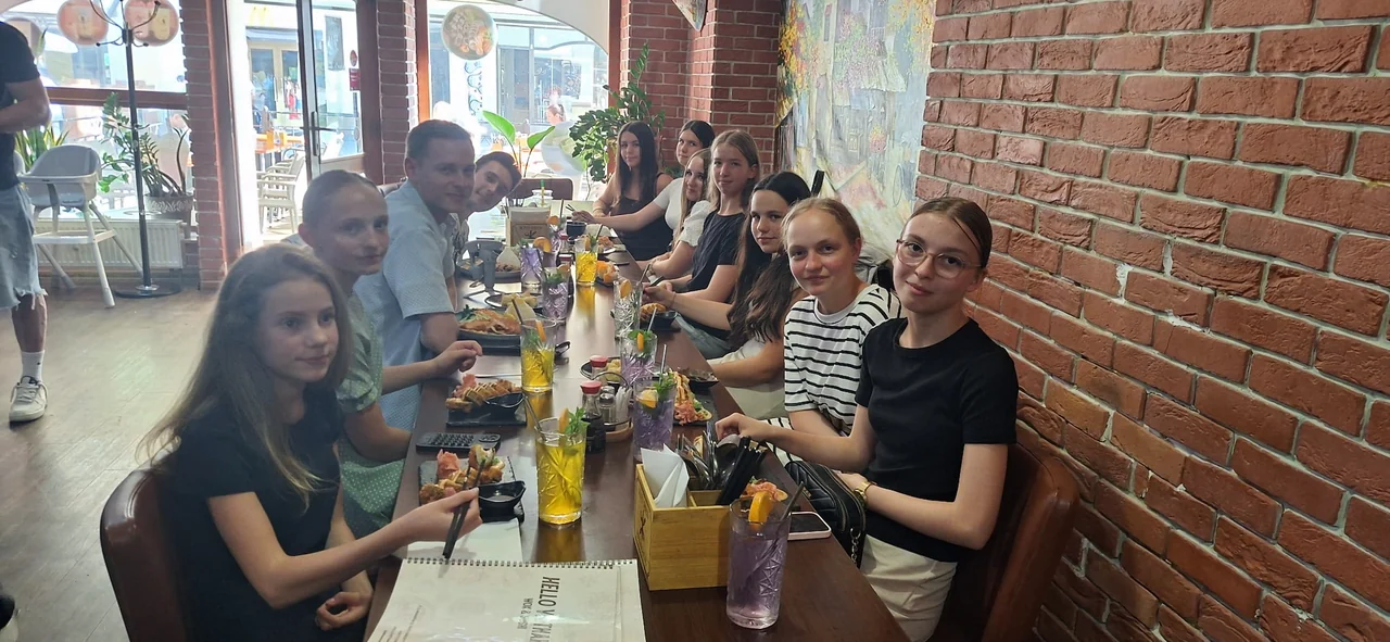 Die Jugend an einer langen Tafel im Restaurant