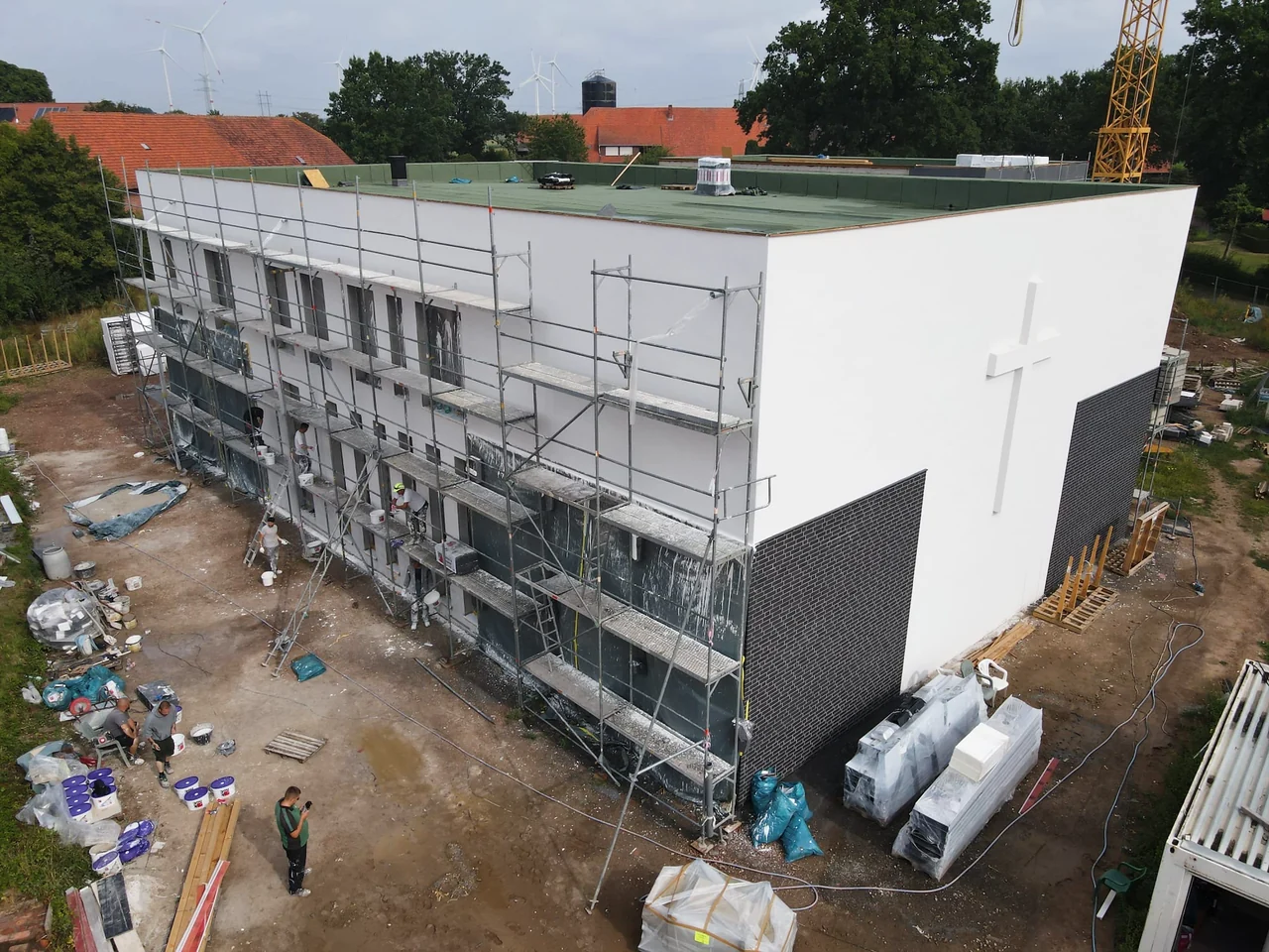 Männer arbeiten auf dem Gerüst an der Fassade der neuen Kirche